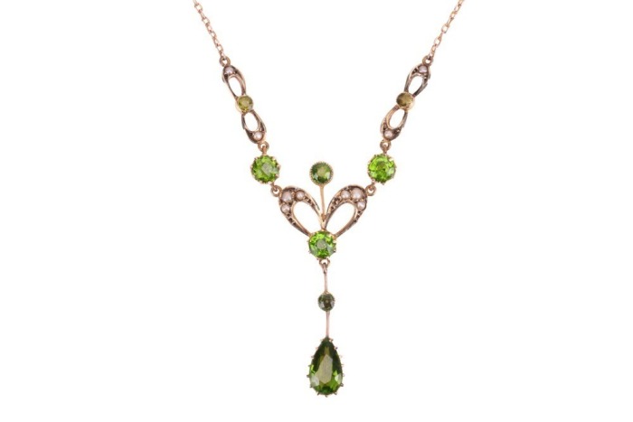 A gem-set lavalier necklace, set with seed pearls and garnet-topped doublets, in a yellow metal mount to a trace link chain with a hook clasp, surface tested as 9ct gold; 3.8 grams. Please note: Unless otherwise stated, lots have been tested using an elec