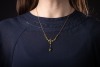 A gem-set lavalier necklace, set with seed pearls and garnet-topped doublets, in a yellow metal mount to a trace link chain with a hook clasp, surface tested as 9ct gold; 3.8 grams. Please note: Unless otherwise stated, lots have been tested using an elec - 4