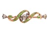 An Edwardian demantoid garnet and diamond bar brooch; centred with collet-set old-cut diamonds, between a bypassing scrollwork mount set with graduated circular-cut demantoid garnets, brooch fittings to the back, unmarked yellow metal testing as 14ct, 3.4