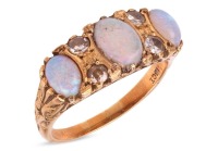An opal and diamond-set half hoop ring, set with three precious opal cabochons, set between single-cut diamonds, in a yellow metal mount marked &lsquo;18ct&rsquo;, size L; 4.7 grams