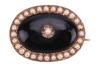 An early 19th century mourning ring, with plaited hair behind the central glass compartment, engraved to the interior: &lsquo;John Hinsum, 26 May, 1802, At 60&rsquo;, in a rose metal mount, surface tested as 9ct, size Q, together with a Victorian onyx and seed pearl - 2