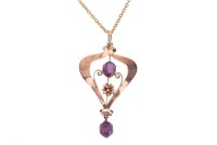 An Edwardian amethyst-set pendant, claw-set with two oval-cut amethysts, in a yellow metal mount of scrolling and floral design, marked &lsquo;9ct&rsquo;, to a base metal chain; total weighable: 1.4 grams