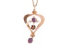 An Edwardian amethyst-set pendant, claw-set with two oval-cut amethysts, in a yellow metal mount of scrolling and floral design, marked &lsquo;9ct&rsquo;, to a base metal chain; total weighable: 1.4 grams - 3
