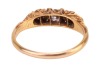 A diamond, pearl and coral half-hoop ring, centred with a round brilliant-cut diamond, flanked by two split pearls and two corallium rubrum cabochons, in a scrolled mount leading to a D-profile shank, in yellow metal stamped '18ct', size L, 2.2 grams. Dia - 3