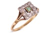 An emerald and diamond dress ring; centred with a square-cut emerald of 2.5 mm, within a scalloped frame surround set with single-cut diamonds, between trifurcated shoulders to D-profile shank marked '18ct', ring head measures 1.0 cm wide, size V, 3.8 gra