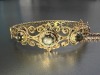 A hinged bracelet set with black star sapphires; the openwork scrolled mount with twisted rope border and beaded accents, set with three graduated oval black star sapphire cabochons, fastens with a tongue clasp with push-in thumbpiece, in yellow metal sta - 5