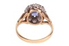 A sapphire and diamond cluster ring in 18ct, centred with an oval-cut sapphire of 6.7 x 4.6 x 3.2mm, encompassed by ten round brilliant-cut diamonds with an estimated total weight of 0.57ct, between foliate shoulders, ring head 1.3 x 1.1 cm, size L, 3.8 g - 3