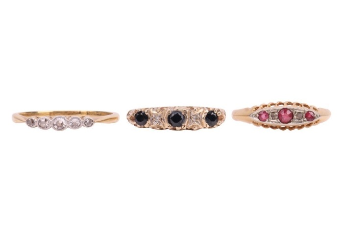Three rings; comprising a diamond-set five-stone ring, with five graduated single-cut diamonds, in a yellow metal mount marked &lsquo;18ct&rsquo;, size O, a sapphire and diamond-set half hoop ring, in a 9ct yellow gold mount, size O, and a paste and diamond-set ring,