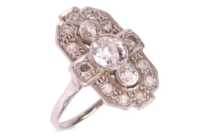 An early 20th-century diamond-set plaque ring; composed of three central bezel-set old-cut diamonds, the largest measuring approximately 6.1mm with an estimated carat weight of 0.85ct, flanked by two old-cut diamonds measuring approximately 3mm each, in a