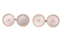 A pair of mother-of-pearl cufflinks, of circular form, each set with an engraved mother-of-pearl panel, centred with a split pearl accent, within a white enamelled frame, in yellow metal surface testing as 14ct, panel measures 1.3 cm across, 4.1 grams. Pl