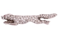 A diamond-set fox brooch, sculpted as a running fox, fully encrusted with single-cut diamonds, with a ruby cabochon as eye, later brooch fittings to the reverse, unmarked white metal surface testing as 18ct, 4.0 cm wide, 4.1 grams. Please note: Unless oth