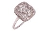 An Art Deco style panel ring, centrally-set with a bezel-set round brilliant diamond, within a diamond-set openwork panel, to a white metal shank marked &lsquo;plat&rsquo;, size N; 3.3 grams.