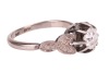 A late Art Deco diamond solitaire ring, centred with an Old-European cut diamond of 5.6 mm, estimated weight 0.70ct, in a buttercup mount between foliate shoulders, white metal stamped '18ct PLAT', size M&frac12;, 3.4 grams. Diamond approximately measures 5.6 x - 4