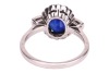 A sapphire and diamond cluster ring; the oval mixed-cut sapphire claw mounted within a border of fourteen round brilliant cut diamonds, with two calibr&eacute; cut sapphires to each shoulder. Plain D-shaped shank, unmarked, shank surface testing as 14ct and moun - 3
