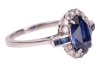 A sapphire and diamond cluster ring; the oval mixed-cut sapphire claw mounted within a border of fourteen round brilliant cut diamonds, with two calibr&eacute; cut sapphires to each shoulder. Plain D-shaped shank, unmarked, shank surface testing as 14ct and moun - 4
