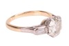 A diamond solitaire ring, the central diamond measuring approximately 7.5mm, with an estimated carat weight of 1.70ct, flanked by two bezel-set baguette-cut diamonds, in a bi-colour metal mount marked &lsquo;18ct&rsquo;, size L; 3.8 grams. - 3