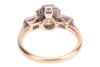 A diamond solitaire ring, the central diamond measuring approximately 7.5mm, with an estimated carat weight of 1.70ct, flanked by two bezel-set baguette-cut diamonds, in a bi-colour metal mount marked &lsquo;18ct&rsquo;, size L; 3.8 grams. - 4