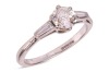 A diamond-set ring, composed of an old European cut diamond in a six-prong setting, measuring approximately 5.7mm with an estimated carat weight of 0.70ct, flanked by two tapered baguette-cut diamonds, to an 18ct white gold mount, size L; 2.5 grams