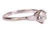 A diamond-set ring, composed of an old European cut diamond in a six-prong setting, measuring approximately 5.7mm with an estimated carat weight of 0.70ct, flanked by two tapered baguette-cut diamonds, to an 18ct white gold mount, size L; 2.5 grams - 4