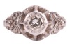 A diamond-set solitaire ring, composed of an illusion-set round brilliant cut diamond, measuring approximately 4.5mm, with an estimated carat weight of 0.36ct, the high gallery leading to foliate-style shoulders, to a white metal shank marked &lsquo;18ct&rsquo;, size - 3