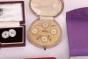 A matched gold, mother-of-pearl and sapphire dress set, in fitted case; together with a pair of silver, mother-of-pearl and enamel cufflinks, adapted from buttons, with later links; two sets of six gilt metal and enamel buttons in fitted cases, circa 1910 - 3