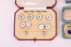 A matched gold, mother-of-pearl and sapphire dress set, in fitted case; together with a pair of silver, mother-of-pearl and enamel cufflinks, adapted from buttons, with later links; two sets of six gilt metal and enamel buttons in fitted cases, circa 1910 - 6