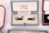 A matched gold, mother-of-pearl and sapphire dress set, in fitted case; together with a pair of silver, mother-of-pearl and enamel cufflinks, adapted from buttons, with later links; two sets of six gilt metal and enamel buttons in fitted cases, circa 1910 - 8