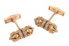 A pair of Etruscan-style cufflinks, of hollow scroll holder form, with twisted cable and granulated details, accentuated with a line of navy enamel at the centre, toggle fittings with personal inscription, in yellow metal stamped 'K18', 2.8 cm wide, 18.5 