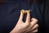 A lion statant brooch, realistically sculpted with fur texture, adorned with a round brilliant-cut diamond by one of its paws and eyes highlighted with rubies; brooch fittings to the reverse; yellow metal stamped '18K'; 5.5 cm wide; 19.6 grams. - 3