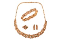An emerald and diamond parure; comprising a necklace, a bracelet, a pair of earrings and a cocktail ring; of textured and braided design, embellished with lines of graduated circular-cut emeralds, and round brilliant-cut diamond clusters; the collar neckl