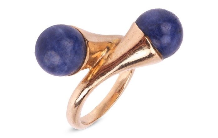 Gucci- a lapis lazuli cross-over ring in 9ct yellow gold, featuring two spherical lapis lazuli bead finials of 8.0 mm, mounted to the tapered bypass shoulders, leading to a D-profile shank, London 1976, sponsor's mark 'FJLd', size E, in original Gucci rin