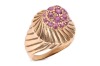 A ruby-set dress ring, featuring a central raised domed cluster of nineteen claw-set round-cut rubies, the domed cluster tapering to a border detailed with diagonal fluting, the diagonal fluting extending to the shoulders, to a plain yellow metal band sur
