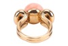 An angelskin coral and diamond dress ring, centred with a button-shaped corallium secundum of 12.6 mm, between bow shoulders adorned with two old-cut diamonds in millgrained collets, with an estimated total weight of 0.28ct, yellow metal stamped '18K', si - 4