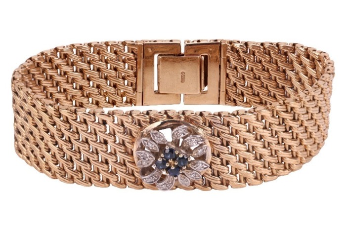 A gem-set bracelet of floral design, centred with a stylised flowerhead set with circular-cut sapphires and diamond accents, to a woven chain of wickerwork pattern, completed with a concealed lever clasp, centrepiece stamped '800 and 585', chain bearing B