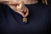 An enamel religious pendant; the rectangular pendant with Florentine finish, depicting a Medieval-style Jesus, set with polychromatic champleve enamel, suspended from a loop bail, in yellow metal bearing Italian assay marks '750', and maker's mark for Tra - 3