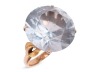 A large synthetic spinel dress ring; set with a round synthetic spinel in pale blue, claw set to a yellow metal mount with floral motif shoulders, to a tapered D-profile shank, marked as '14k', ring head measures 1.9 cm across, ring size M&frac12;, total weight 