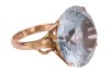 A large synthetic spinel dress ring; set with a round synthetic spinel in pale blue, claw set to a yellow metal mount with floral motif shoulders, to a tapered D-profile shank, marked as '14k', ring head measures 1.9 cm across, ring size M&frac12;, total weight - 3