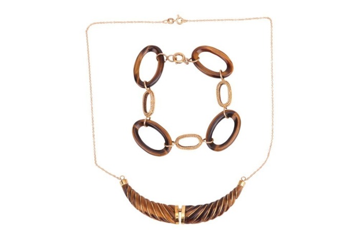 A tiger's eye necklace and a bracelet; the necklace comprising a hinged tiger's eye pendant carved as a twisted horn, with applied stripe decorations, on a fine cable link chain with spring-ring clasp, in yellow metal struck with Italian assay marks for 1