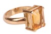 A citrine dress ring, claw-set with a rectangular citrine with canted corners, measures 9.9 x 8.0 x 4.9 mm, to a D-profile shank in yellow metal stamped '18ct' also surface testing as 18ct, size H, 4.8 grams. Please note: Unless otherwise stated, lots hav - 4