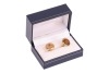 A pair of ruby-set cufflinks, of polished disc form, each centred with an applied round ruby cabochon, toggle fittings to the back, yellow metal stamped '750', signed Serkos and in respective branded case, 1.6 cm wide, 12.5 grams. - 2