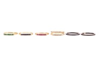 A small group of rings comprising three matching seven-stone rings, each channel-set with calibre-cut gemstones including rubies, emeralds and sapphires, to yellow metal mounts surface tested as 14ct, size U, together with an interchangeable gem-set outer