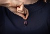 A large synthetic colour change sapphire pendant, claw-set to a reeded mount, on a tapered bail, unmarked metal surface testing as 9ct, 3.7 cm drop, 9.6 grams. Please note: Unless otherwise stated, lots have been tested using an electronic tester. This is - 3
