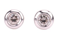 A pair of diamond-set stud earrings, composed of round brilliant diamonds, with an estimated total carat weight of 0.34ct, bezel-set in 18ct white gold mounts, the unassociated white metal earring backs marked &lsquo;9K&rsquo; and the other &lsquo;925&rsquo;; 2.1 grams