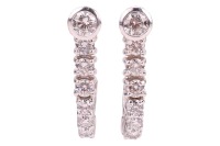 A pair of diamond-set semi-hoop earrings, comprising bezel-set round brilliant diamonds at the surmounts, each with an estimated carat weight of 0.25ct, fixed to a curved row of claw-set diamonds, graduated in size, in 18ct white gold mounts, with post fi