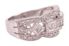 An Art Deco style diamond-set ring, centrally set with a row of four princess-cut diamonds, flanked by an additional two bezel-set princess-cut diamonds, between two scalloped rows of round brilliant-cut diamonds, to a white metal mount marked &lsquo;18K&rsquo; and &lsquo; - 3