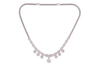 A diamond-set fringe-style necklace, composed of diamond-set openwork links with millegrain detailing, connected with round brilliant diamonds measuring between 3.2mm to 4mm each, suspending six diamond-set floral cluster drops and a larger removable diam