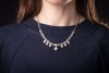 A diamond-set fringe-style necklace, composed of diamond-set openwork links with millegrain detailing, connected with round brilliant diamonds measuring between 3.2mm to 4mm each, suspending six diamond-set floral cluster drops and a larger removable diam - 5