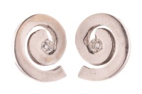 A pair of diamond-set stud earrings in the form of swirls, centrally adorned with a round brilliant-cut diamond accent, screw-back fittings to reverse, white metal bearing Russian assay marks for 14ct, 1.0 cm wide, 2.0 grams.