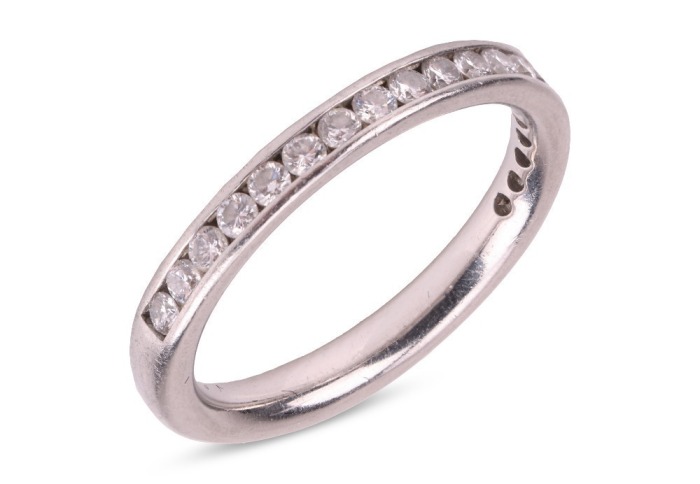 A diamond-set half-eternity ring, featuring a channel of nineteen round brilliant-cut diamonds, set in platinum, size J, 3.5 grams.