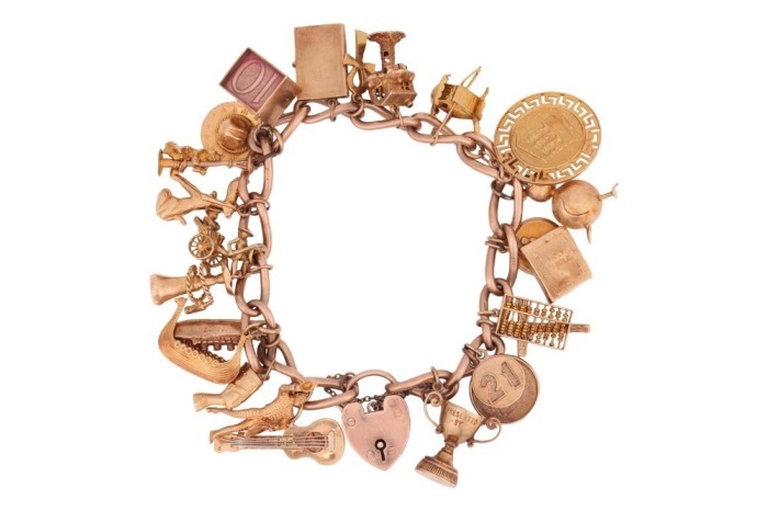 A 9ct gold charm bracelet, suspending twenty four charms, mostly 9ct gold, but including 14ct and 18ct examples; gross weight: 87.5 grams